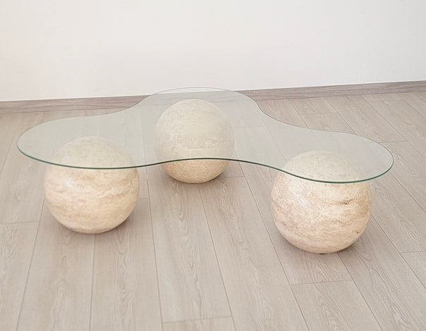 coffee table with three travertine spheres and a glass top