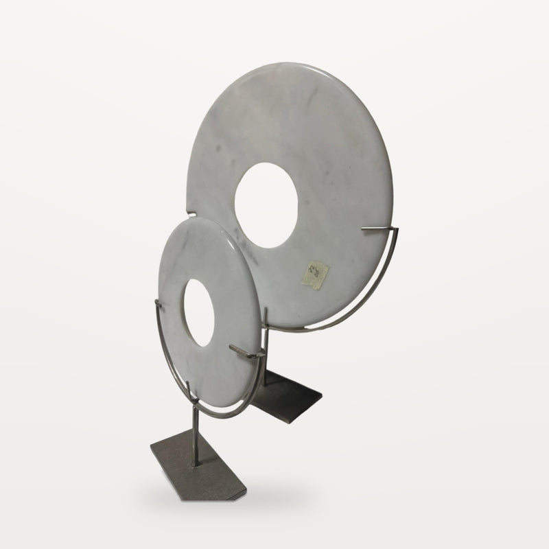 two white marble discs on metal stands